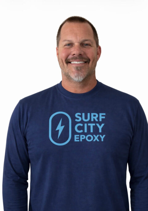 Sean Jensen, founder of Surf City Epoxy, standing in a navy company shirt with the Surf City Epoxy logo.